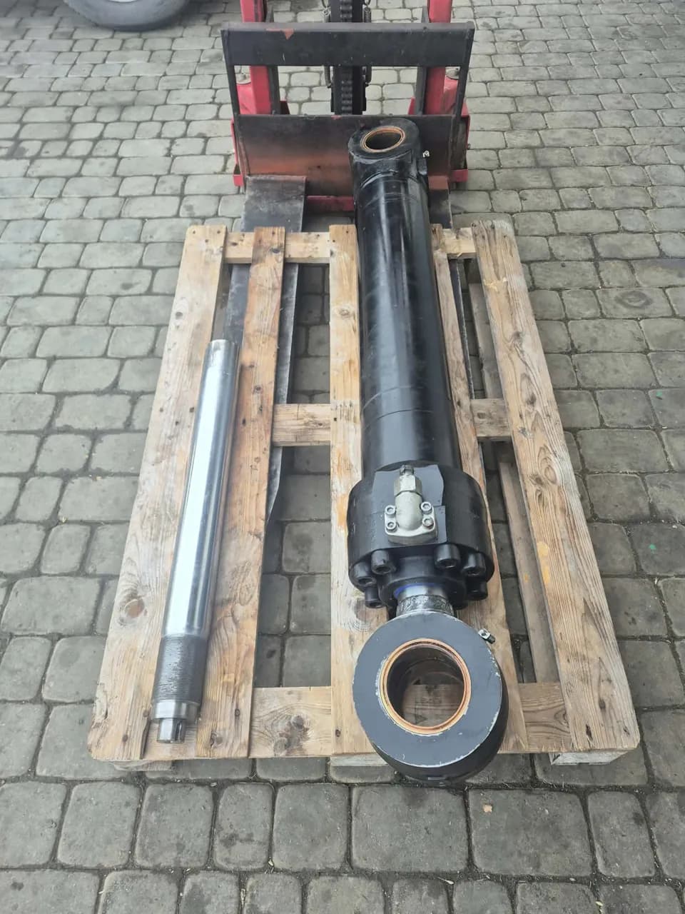 Czarny siłownik hydrauliczny i wyjęte tłoczysko na palecie
