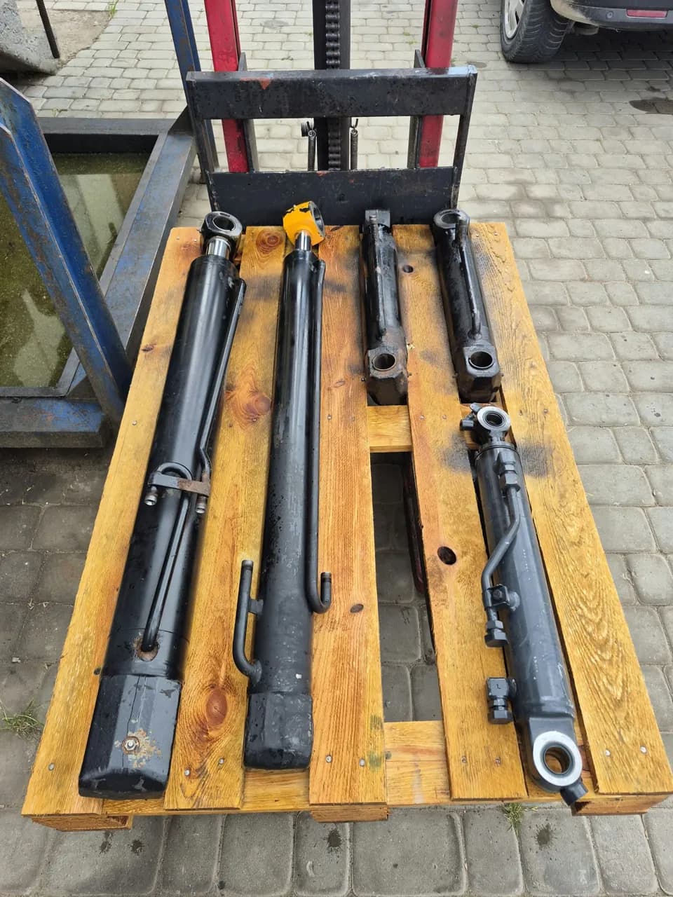 Cztery czarne siłowniki hydrauliczne na palecie