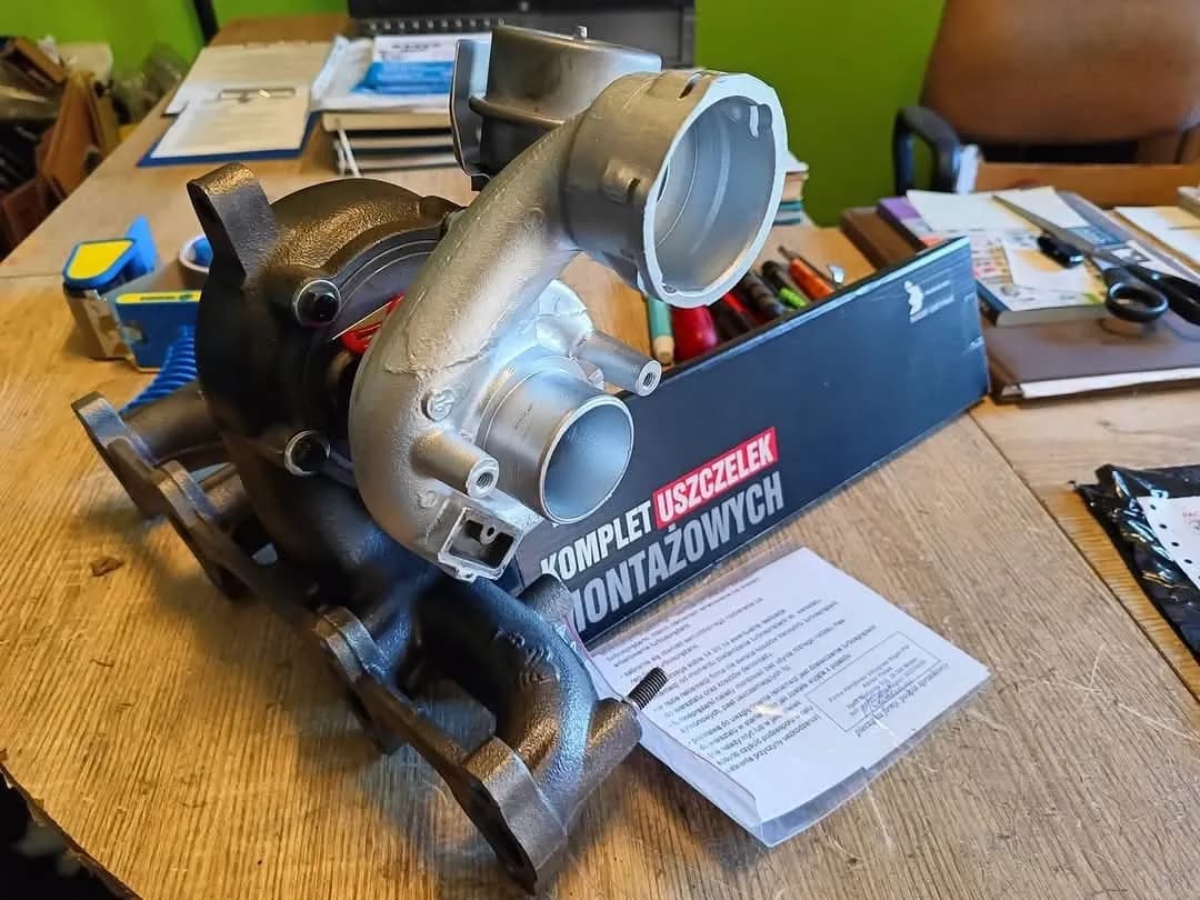 Turbosprężarka z kolektorem wydechowym i kompletem uszczelek montażowych na stole warsztatowym